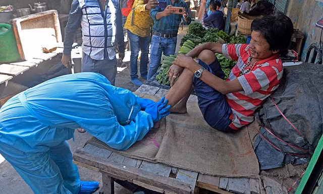 Một nhà hoạt động kêu gọi mọi người trong chợ đeo khẩu trang trong hoạt động nâng cao nhận thức ở Siliguri