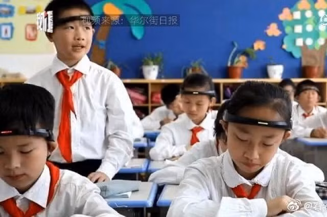 HS sử dụng vòng đeo theo dõi sóng não tại một trường tiểu học ở Junhua, tỉnh Chiết Giang, Trung Quốc.