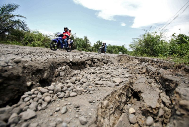 Xe máy chạy qua một đoạn đường bị ảnh hưởng của động đất ở Bengkulu, Indonesia