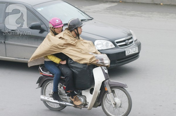 Mấy ngày nay, dù trời tạnh ráo, đường khô nhưng nhiều người vẫn khoác trên mình những chiếc áo mưa để... tránh rét.
