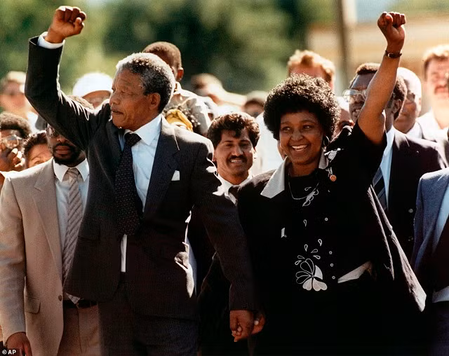 Ông Nelson Mandela và vợ Winnie, tay trong tay, giơ nắm đấm siết chặt khi được thả ra khỏi nhà tù Victor, Cape Town của Nam Phi.