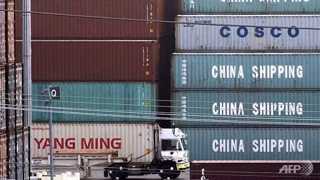 Một chiếc xe tải đi qua containers hàng Trung Quốc tại cảng Los Angeles (Mỹ). Ảnh: AFP.