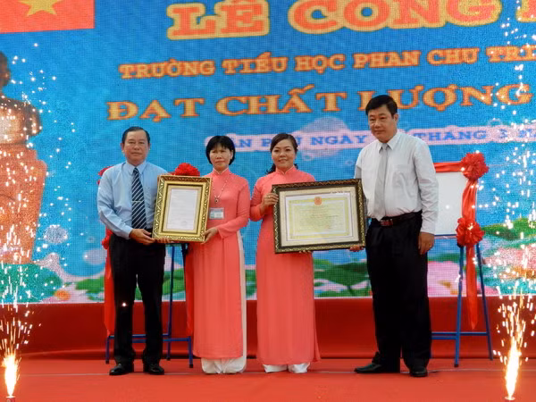 Ông Hồ Phú Bạc - Trưởng phòng Khảo thí và kiểm định chất lượng (Sở GD&ĐT TPHCM) và ông Trần Văn Phúc – Phó Chủ tịch UBND quận Tân Phú trao quyết định, giấy chứng nhận đạt chuẩn kiểm định chất lượng cho lãnh đạo nhà trường.
