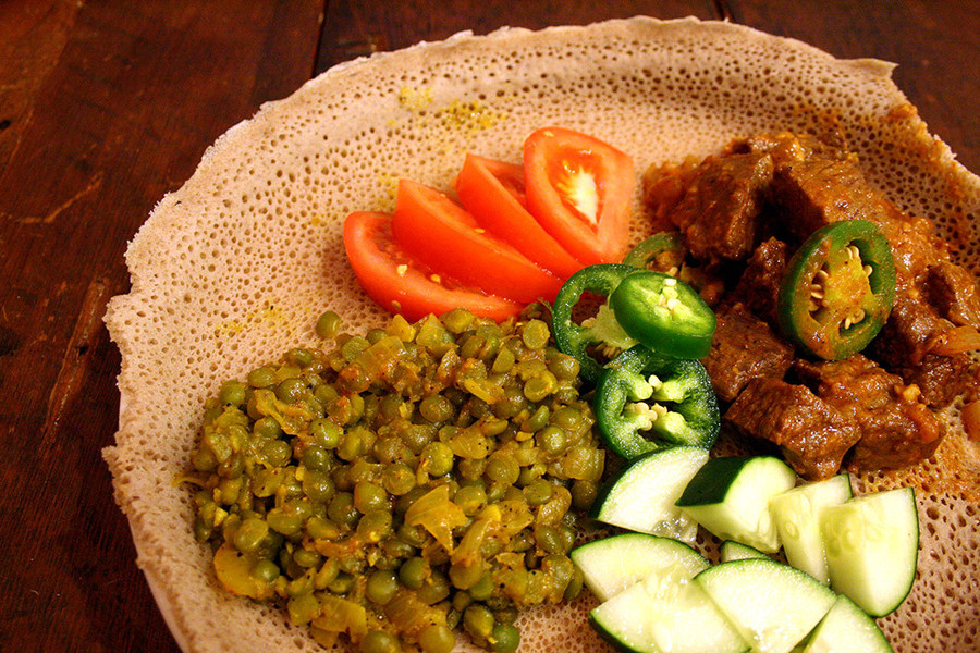 Injera, Ethiopia và Eritrea: Chiếc bánh có độ xốp, được làm từ bột teff lên men, vừa là một món ăn, vừa giống như chiếc đĩa đừng thức ăn. Bánh được xếp lên trên với thịt và các loại rau. Ảnh: Scratchdc. Injera, Ethiopia và Eritrea: Chiếc bánh có độ xốp, được làm từ bột teff lên men, vừa là một món ăn, vừa giống như chiếc đĩa đừng thức ăn. Bánh được xếp lên trên với thịt và các loại rau. Ảnh: Scratchdc.