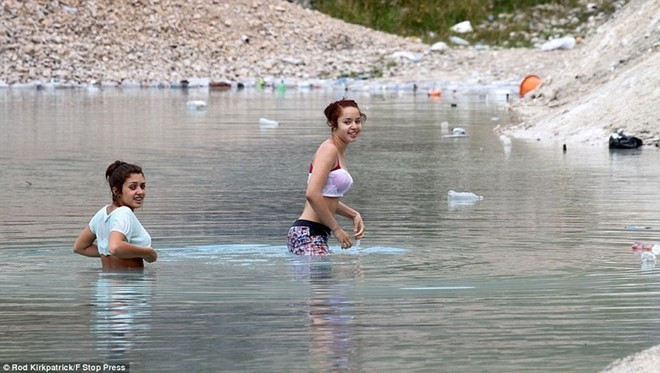 Jayda Thompson, 14 tuổi, và Remece Sabe (mặc áo xanh), 13 tuổi, ngâm cơ thể trong nước Hồ Xanh. Hai thiếu nữ nói rằng họ cảm thấy bình thường khi tắm trong hồ, nhưng họ luôn để phần đầu ở phía trên mặt nước. Jayda