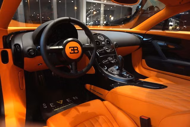 Bugatti Veyron Super Sport đời 2014 đã qua sử dụng. Xe được trang bị động cơ W16 nổi tiếng, màu sơn ngoại thất đặt hàng và nội thất màu cam nổi bật.