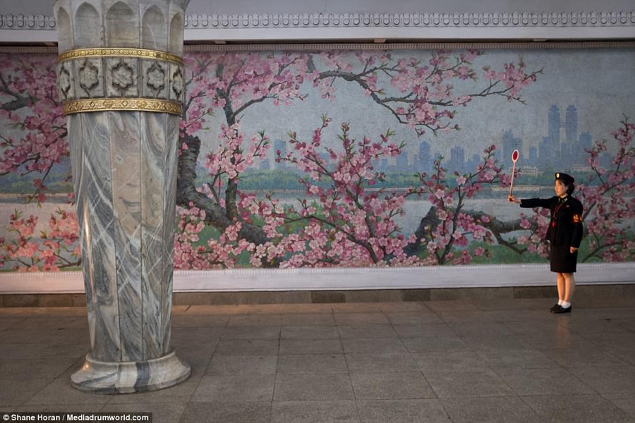 Một công nhân nhà ga Glory ở Bình Nhưỡng đang đón một chiếc tàu chuẩn bị tới.