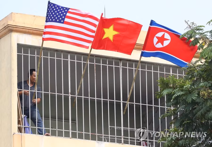 Một người đang cắm quốc kỳ Mỹ, Việt Nam và Triều Tiên tại một ngôi nhà gần khách sạn JW Marriot - nơi TT Trump có thể nghỉ khi tới dự thượng đỉnh. (Ảnh: Yonhap)