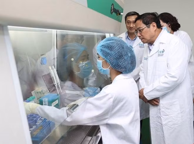 Thủ tướng xem quy trình bảo quản mẫu hài cốt liệt sỹ. (Ảnh: Dương Giang/TTXVN).