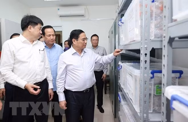 Thủ tướng xem quy trình bảo quản mẫu hài cốt. (Ảnh: Dương Giang/TTXVN).