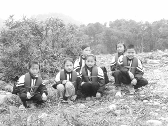 Các em HS ngồi đợi đò để đến lớp