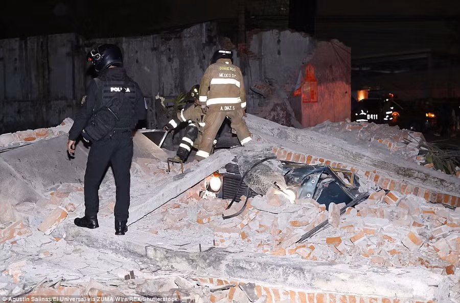 Nhân viên cứu hộ tìm kiếm nạn nhân trong đống đổ nát