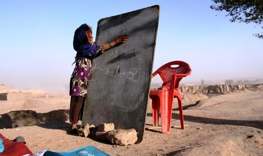 Một bé gái viết lên bảng