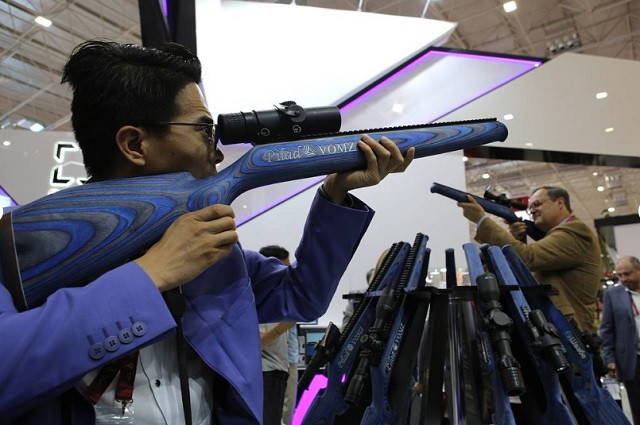 Một khách tham quan thử dùng hiện vật triển lãm Một khách tham quan thử dùng hiện vật triển lãm