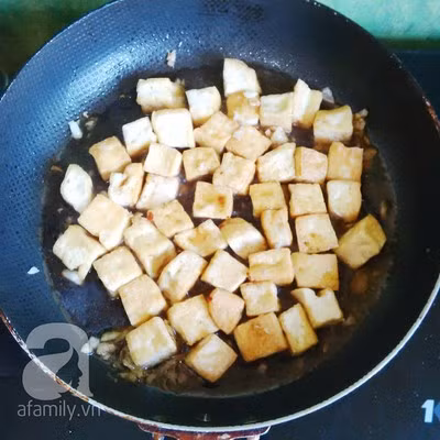 Thêm nước tương đã pha vào, đảo đều cho hỗn hợp nước sốt ngấm vào đậu phụ.