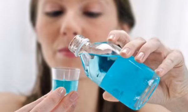 3. Sử dụng nước súc miệng: Súc miệng và sử dụng nước súc miệng là hai việc hoàn toàn khác nhau. Nếu bạn súc miệng bằng nước thông thường, bạn không thể tiêu diệt hết vi khuẩn gây mảng bám trong miệng. Tuy nhiên, nước súc miệng sát khuẩn chuyên dụng sẽ giúp ngăn ngừa mảng bá tích tụ, đồng thời mang lại hơi thở thơm tho. Ảnh: Theguardian.