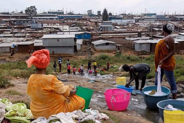 Jackline Bosibori giặt đồ tại một vũng nước ở Kibera.