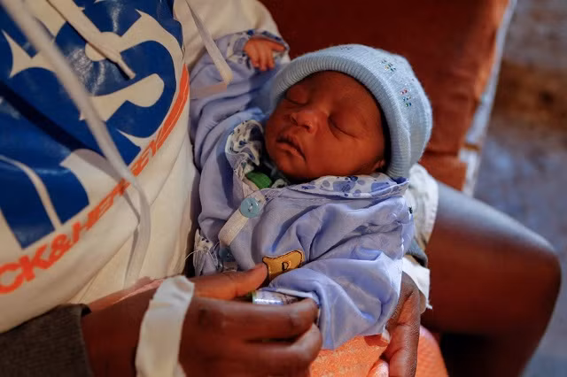 Jackline bế con gái mới sinh của cô ấy trong nhà của họ ở Lindi, Kibera