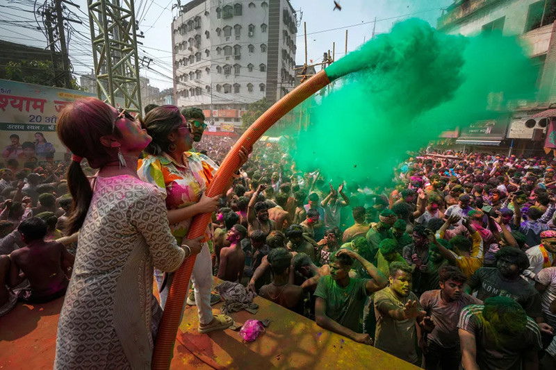 Phụ nữ phun bột màu lên người tham gia lễ hội Holi ở Guwahati, đông bắc Ấn Độ. (Ảnh: Anupam Nath/AP). Phụ nữ phun bột màu lên người tham gia lễ hội Holi ở Guwahati, đông bắc Ấn Độ. (Ảnh: Anupam Nath/AP).
