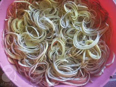 Hoa chuối tách bỏ phần bẹ già, lấy phần non, thái mỏng theo chiều ngang sau đó ngâm vào chậu nước đun sôi đã cho sẵn giấm và chút muối tinh để hoa chuối không bị thâm.