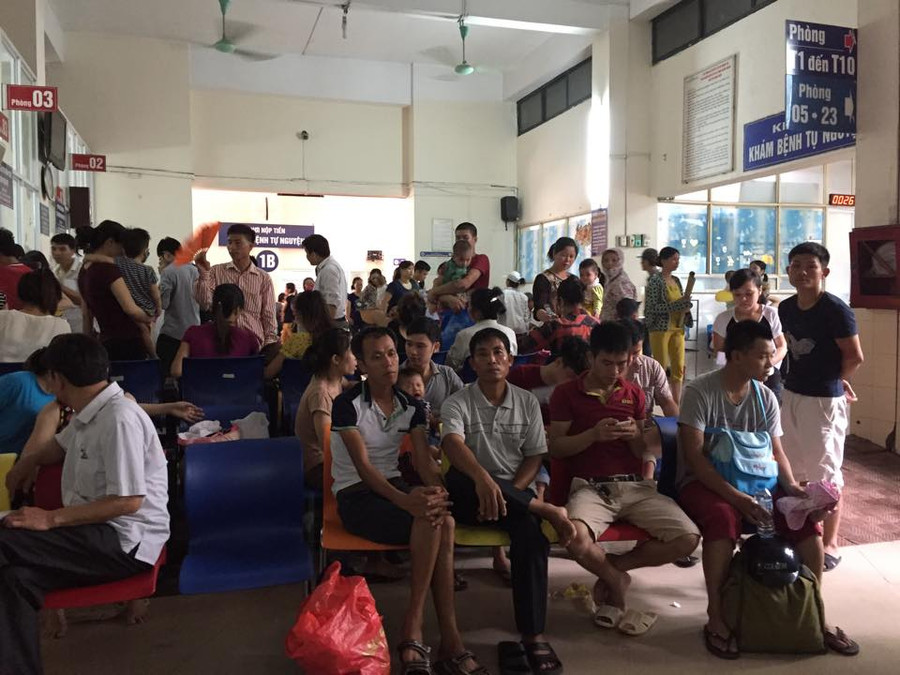 Người nhà bệnh nhi mệt mỏi ngồi chờ khám bệnh.
