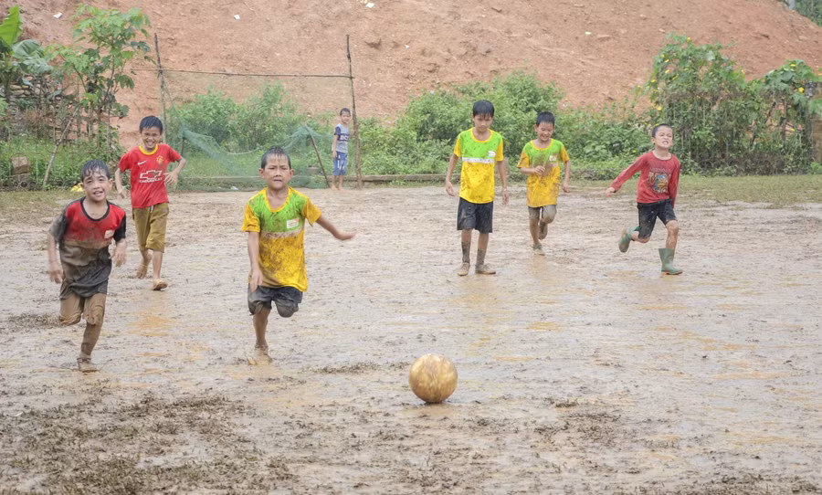 Ướt nhèm trong mưa nhưng vẫn phấn khích với trái bóng.