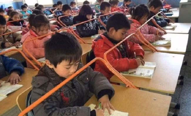 Những thanh sắt giúp học sinh giữ khoảng cách giữa mắt và vở để tránh cận thị ở Vũ Hán, Trung Quốc