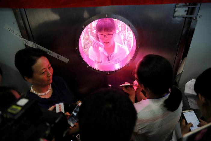 Một tình nguyện viên bên trong cabin trả lời câu hỏi của báo chí