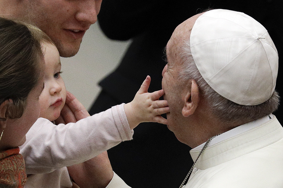 Một bé gái vuốt má Giáo hoàng Francis