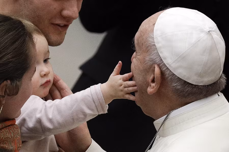 Một bé gái vuốt má Giáo hoàng Francis