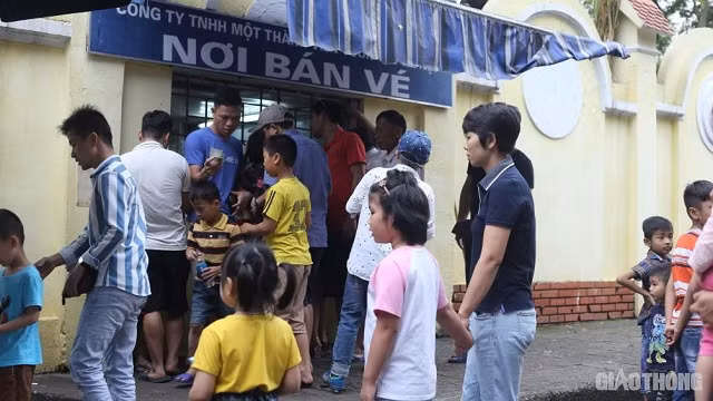 Du khách chen chân mua vé vào cửa trong khi nhân viên bán vé làm việc không ngừng tay.