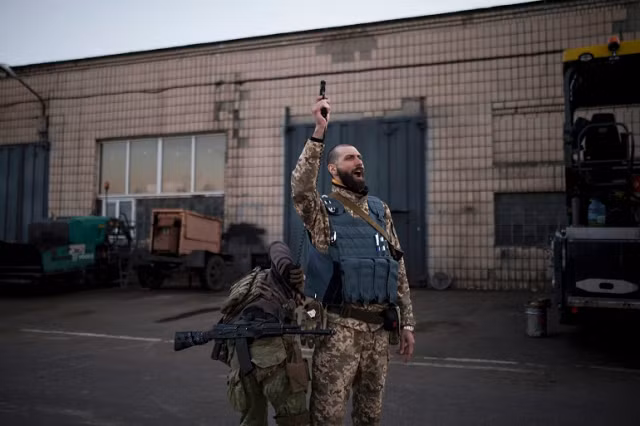 Một chỉ huy trong Lực lượng Phòng vệ Lãnh thổ Ukraine, bắn súng lục trong một trại huấn luyện cho các tình nguyện viên ở Brovary, đông bắc Kiev, Ukraine