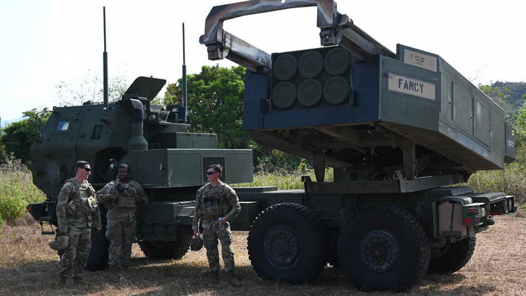 Binh sĩ quân đội Mỹ đứng cạnh bệ phóng hệ thống tên lửa pháo binh cơ động cao (HIMARS). (Ảnh: AFP)