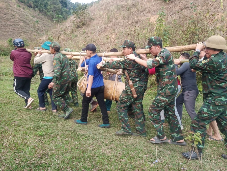 Cán bộ, chiến sĩ Ban Chỉ huy quân sự TP. Điện Biên Phủ cùng dân quân và người dân di chuyển quả bom đến nơi hủy nổ. Ảnh: Hà Khánh