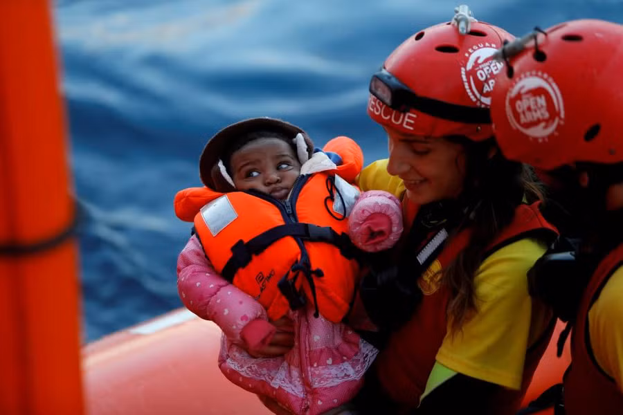 Nhóm cứu hộ Tây Ban Nha bế một em nhỏ nhập cư tại Địa trung hải gần Libya.