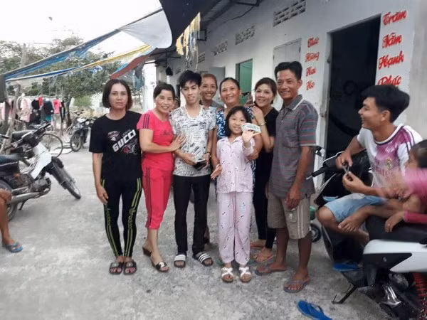 Chàng trai chụp ảnh cùng gia đình hảo tâm.