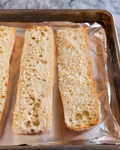 Đặt bánh mì vào khay nướng có lót giấy bạc.