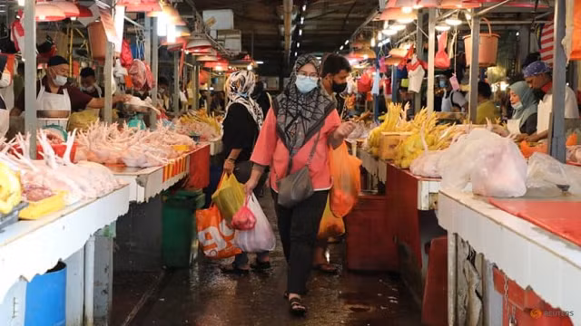 Người Malaysia đeo khẩu trang đi chợ.