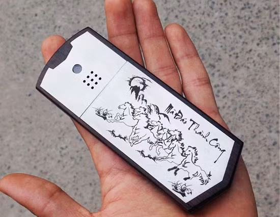 Tranh phong thủy “Mã đáo thành công” trên một chiếc điện thoại vỏ gỗ phối cùng inox.