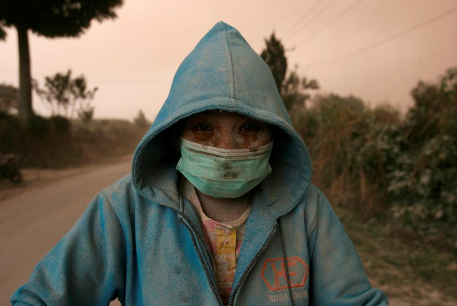 Một người dân làng bị tro bụi bao phủ sau khi một ngọn núi lửa phun trào tại Đỉnh Sinabung, Karo, bắc Sumatra, Indonesia