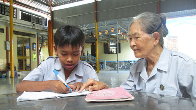 Cô Ngọc Xương hướng dẫn một học trò viết chính tả - Ảnh: Lan Ngọc