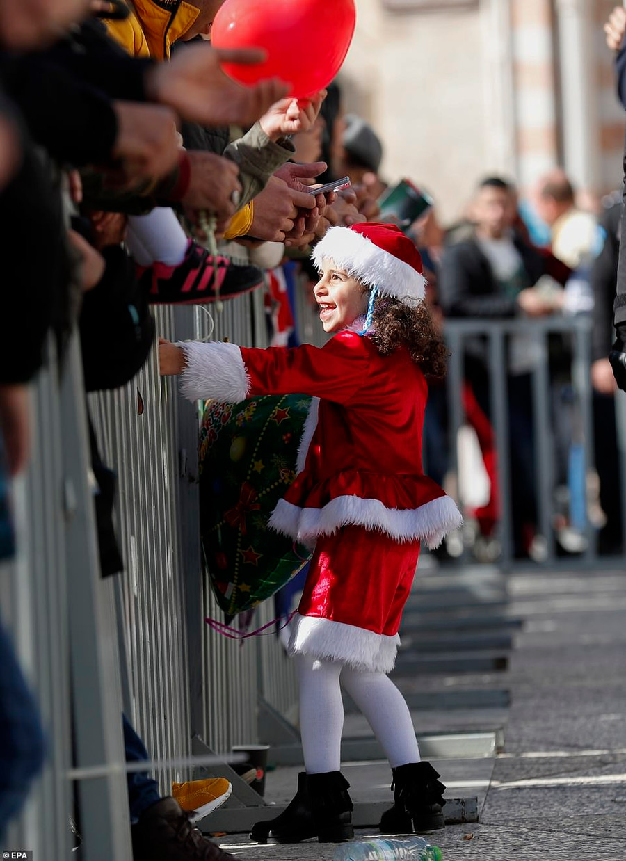 Một bé gái mặc trang phục ông già Noel vào đêm Giáng sinh tại Quảng trường Manger dẫn đến Nhà thờ Giáng sinh ở thị trấn Bethlehem ở Bờ Tây. Một bé gái mặc trang phục ông già Noel vào đêm Giáng sinh tại Quảng trường Manger dẫn đến Nhà thờ Giáng sinh ở thị trấn Bethlehem ở Bờ Tây.