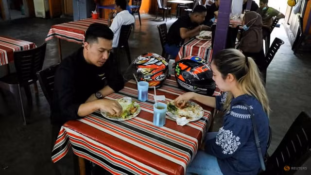 Người được tiêm chủng đầy đủ dùng bữa tại một nhà hàng, giữa lúc bùng phát COVID-19 ở Kuala Lumpur, Malaysia.