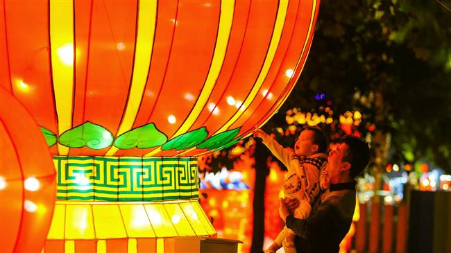 Khách qua đường xem chiếc đèn lồng khổng lồ tại Haikou, Hainan, Trung Quốc Khách qua đường xem chiếc đèn lồng khổng lồ tại Haikou, Hainan, Trung Quốc