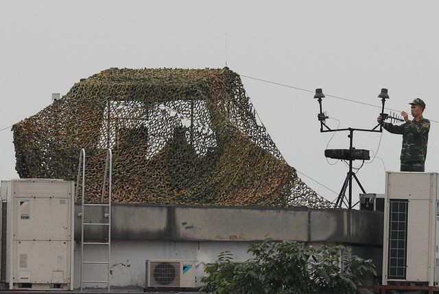 Lắp đặt các thiết bị trên mái nhà. Ảnh Reuters Lắp đặt các thiết bị trên mái nhà. Ảnh Reuters