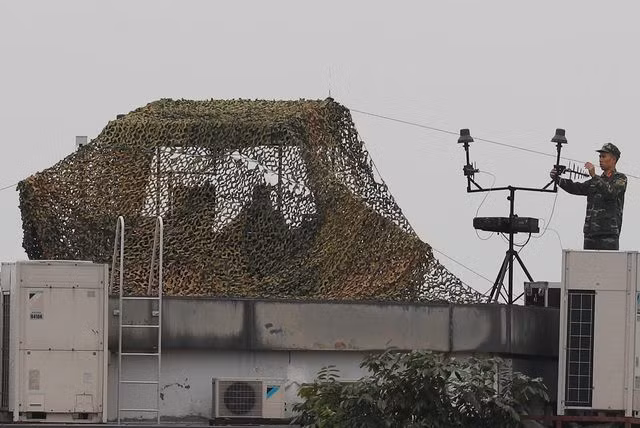 Lắp đặt các thiết bị trên mái nhà. Ảnh Reuters