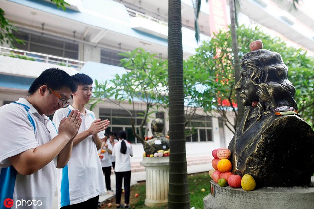 Thí sinh cầu nguyện trước tượng Isaac Newton