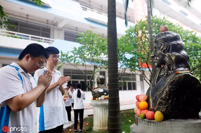 Thí sinh cầu nguyện trước tượng Isaac Newton