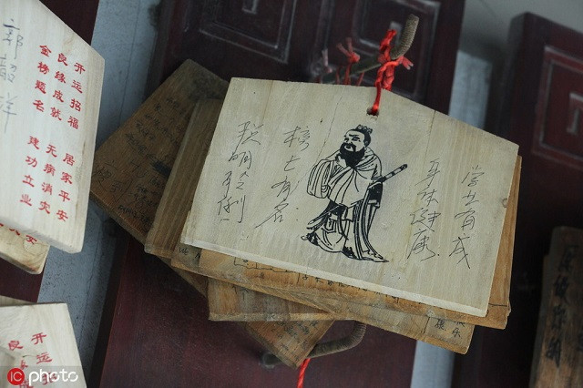 Một tấm gỗ với một bức chân dung của Khổng Tử kèm những điều ước trong một ngôi đền ở Zhengzhou
