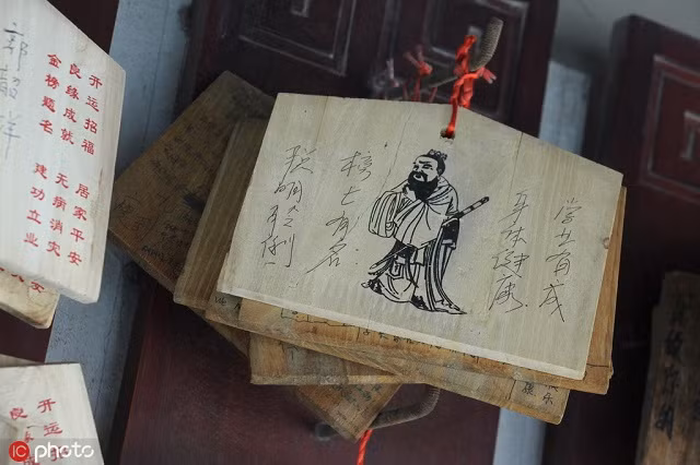 Một tấm gỗ với một bức chân dung của Khổng Tử kèm những điều ước trong một ngôi đền ở Zhengzhou